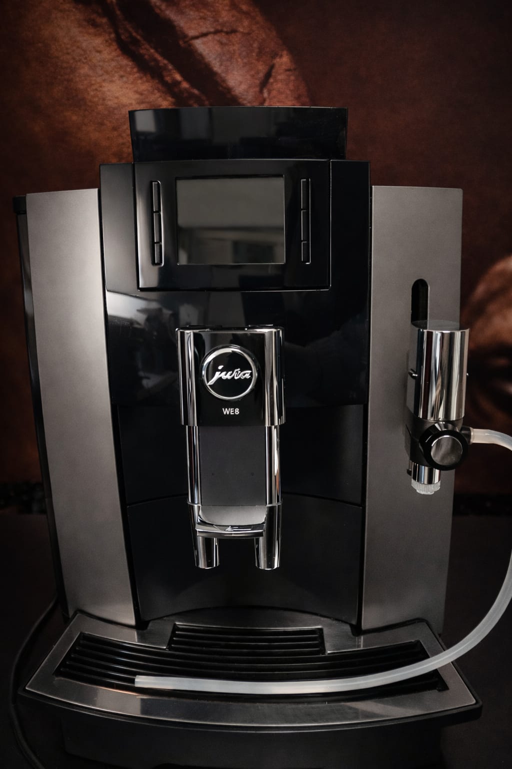 Profesjonalny biurowy ekspres automatyczny Jura WE8 Chrome ze stalowymi akcentami, kolorowym wyświetlaczem TFT, dyszą Fine Foam G2 do spieniania mleka i powiększonym zbiornikiem na wodę 3 litry, widok z przodu na białym tle