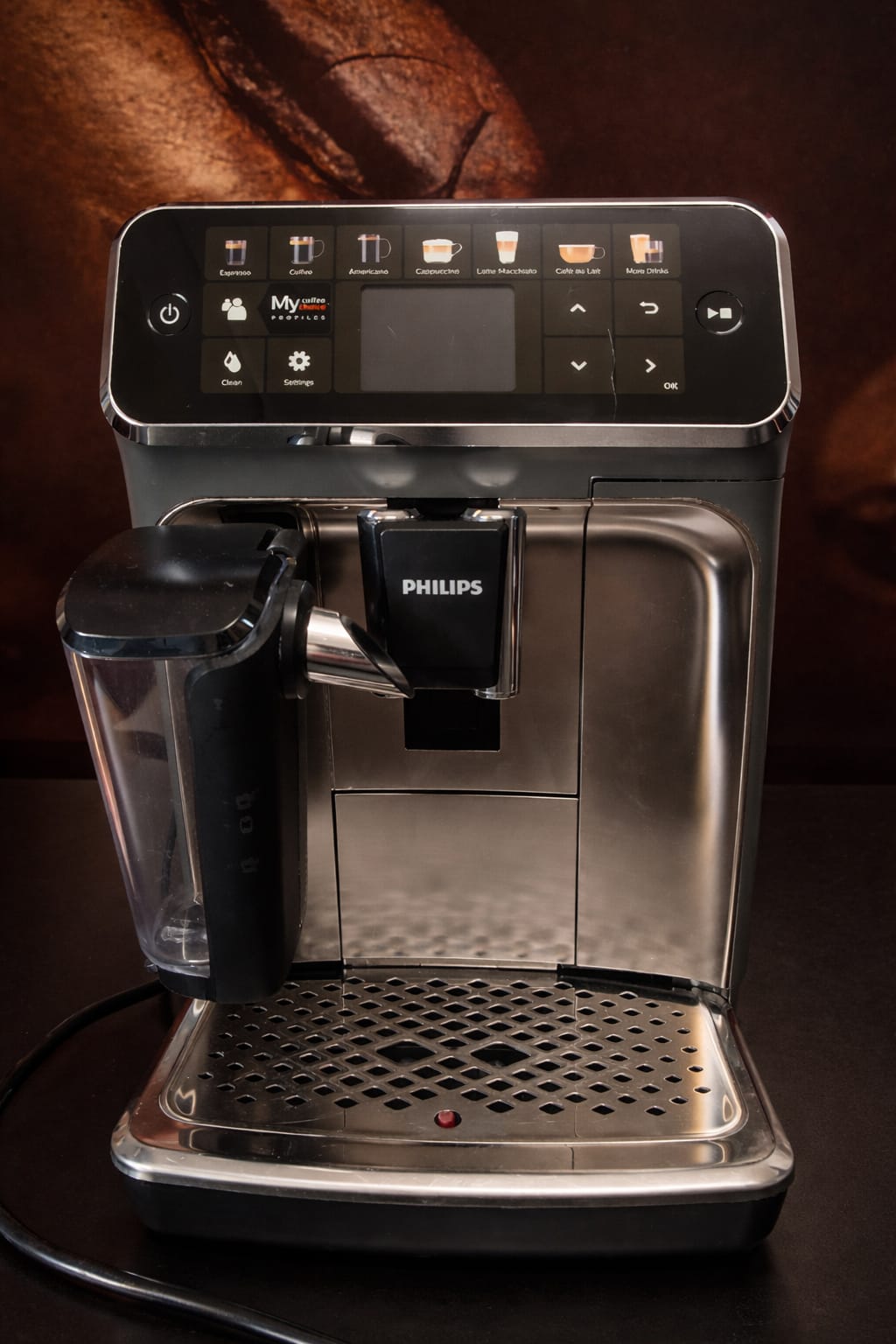 Szary ekspres automatyczny Philips 5400 Series LatteGo EP5444/90 z dotykowym wyświetlaczem kolorowym, dwuczęściowym systemem mlecznym LatteGo i ceramicznym młynkiem, widok z przodu na białym tle